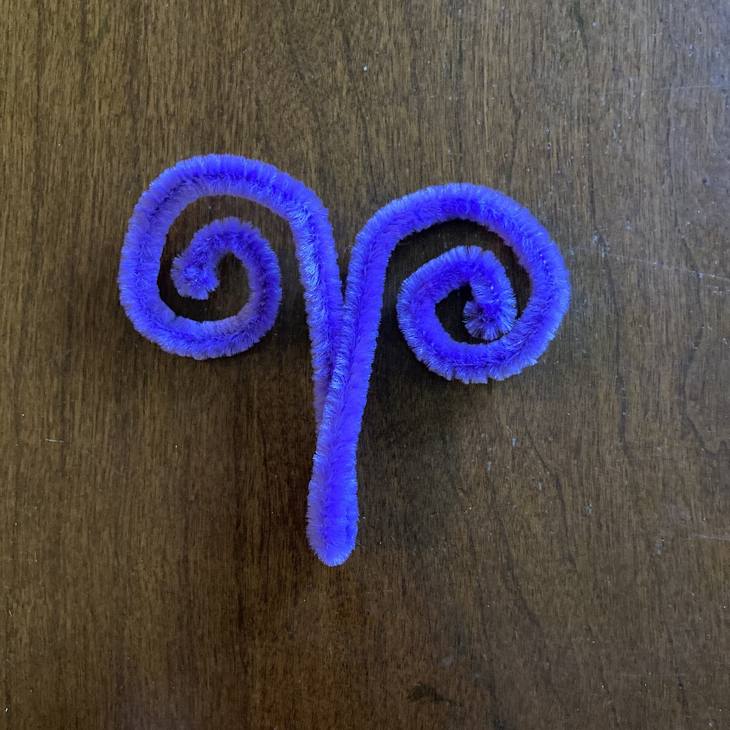 A purple pipe cleaner folded in half and curled to resemble antenna.